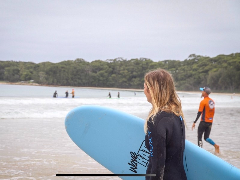 vrouw met surfboard op het strand