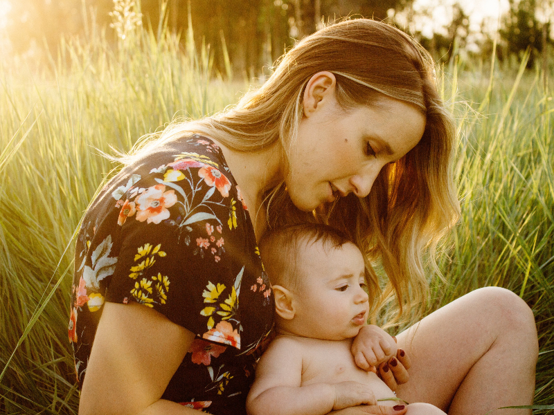 Moeder en haar baby in het gras