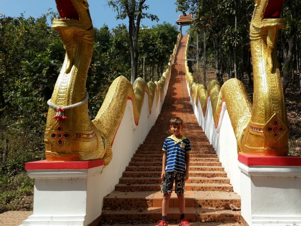 Poseren bij de trap naar een tempel in Noord-Thailand