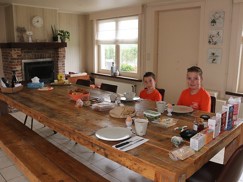 De grote eettafel in de royale woonkeuken met open haard