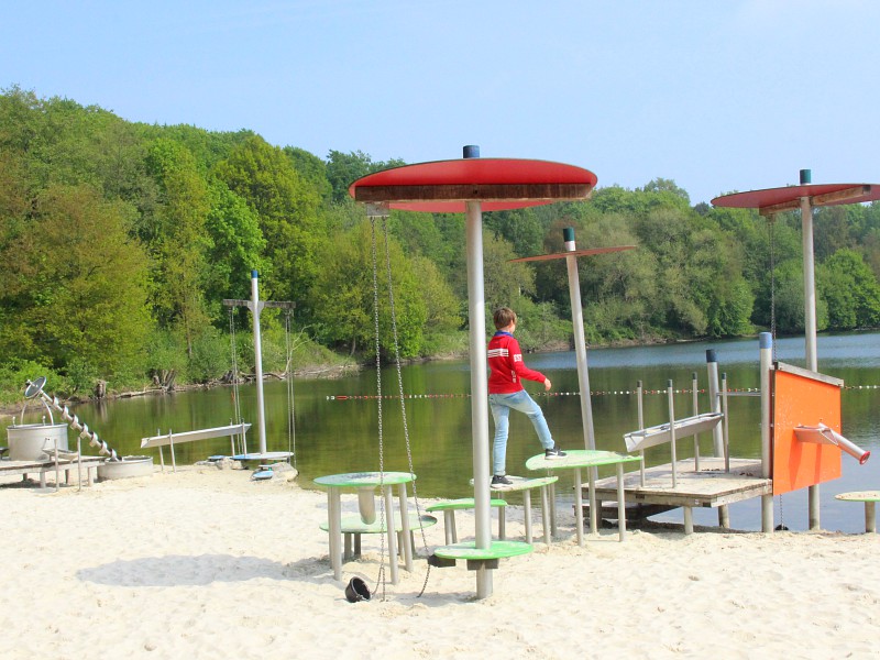 Spelen op de speeltoestellen op het strandje bij Borken am See