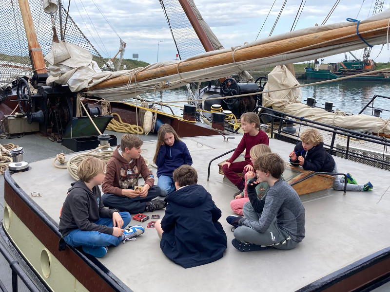 De kinderen zitten een spel te spelen op het schip de Bree Sant