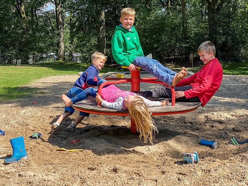 Kinderen spelen in een speeltuintje op de camping