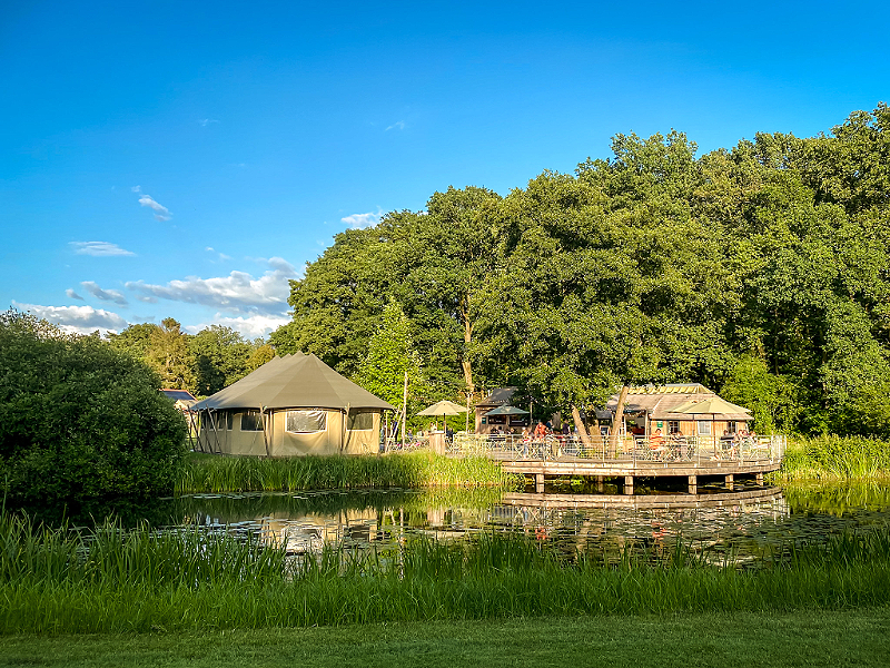 Het terras met de pizzabar aan het water op camping de Roos
