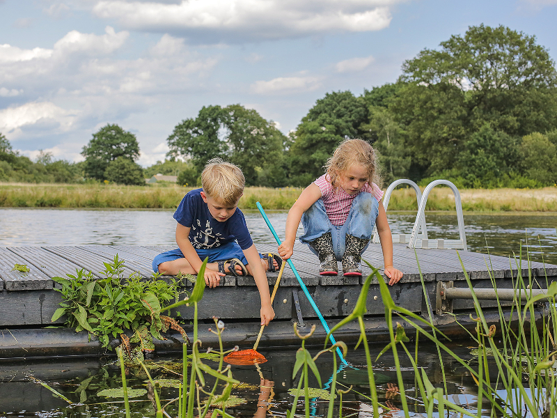 Kinderen vissen in de rivier de vecht op de camping