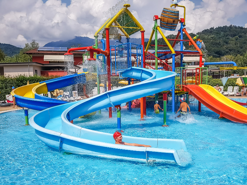 De kinderen genieten van de glijbanen op de Italiaanse camping Isolino nabij het Lago Maggiore