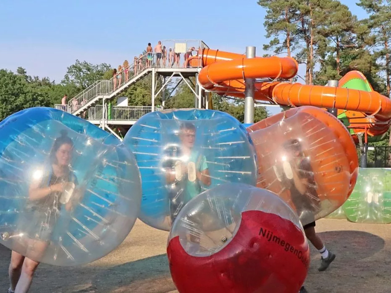 Animatie op camping Ommerland met de glijbanen op de achtergrond.