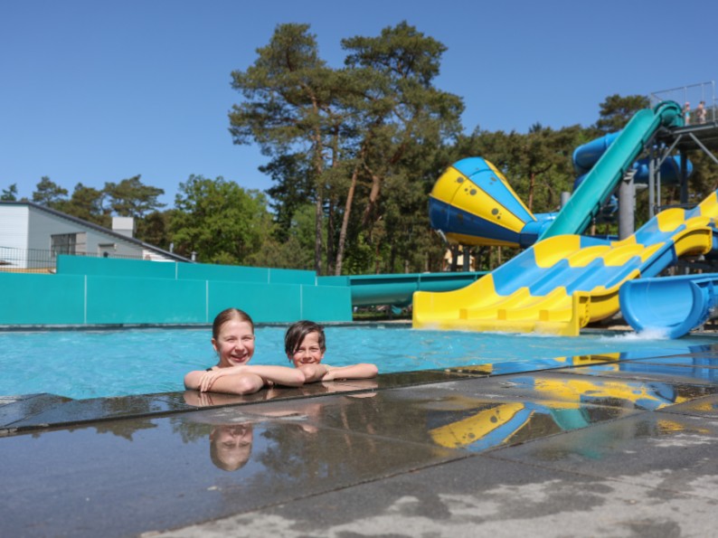 Lara en Duuk met op de achtergrond de glijbanen van camping Samoza
