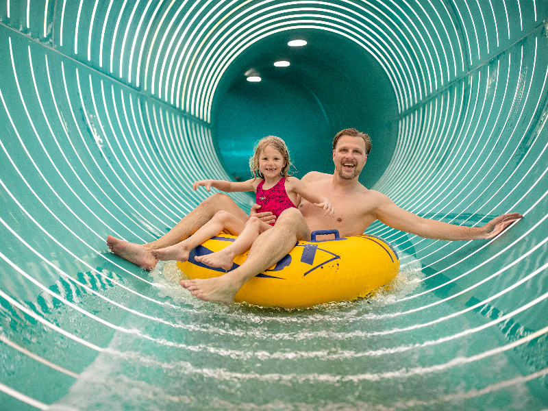 Vader en dochter in één van de 15 glijbanen van Center Parcs Allgau in Duitsland