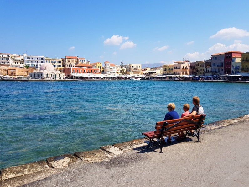 Patrick en de kinderen op een bankje in de haven van Chania