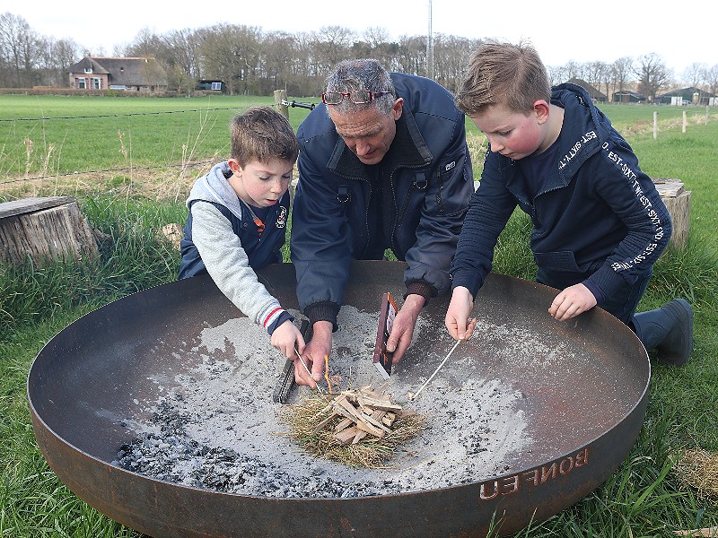 Samen met papa een vuurtje maken.