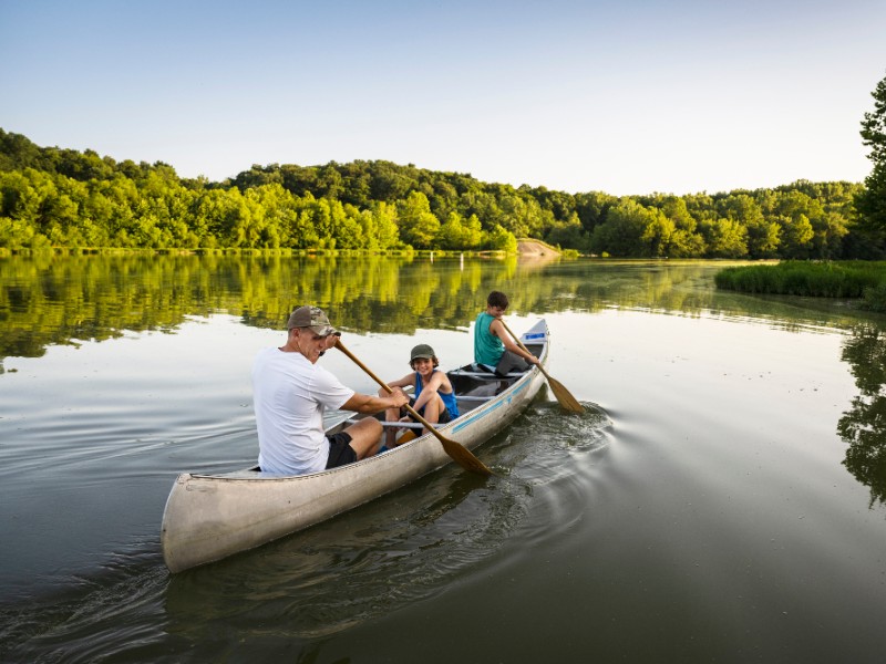 vader met kinderen voor het hotel op het water