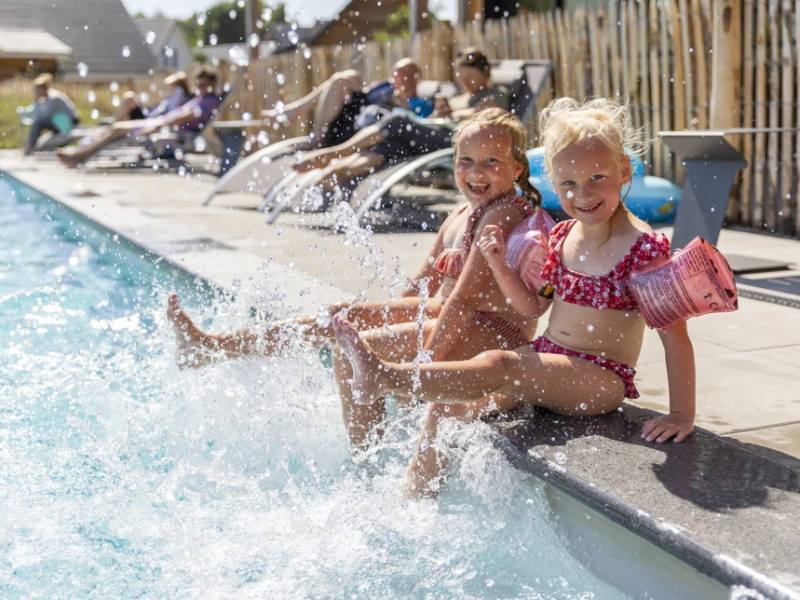 Kinderen spetteren in het zwembad bij Dormio vakantiepark Berck-sur-mer in Noord Frankrijk