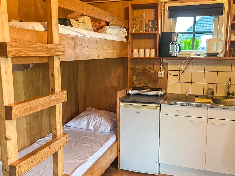 Onze zoon in het stapelbed in ons hutje. Het is klein maar fijn en slim ingericht!