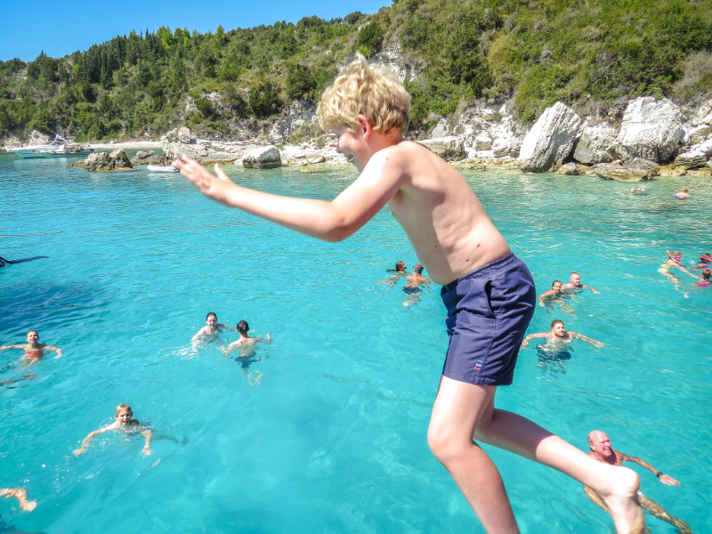 Zeb springt in het water tijdens onze eilandhopreis in Griekenland
