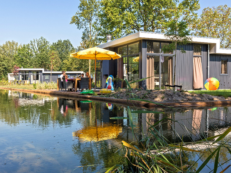 Gezin bij de chalet aan het water bij Resort Limburg