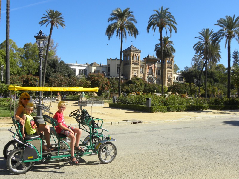 Op een familiefiets in Parque Maria Luisa in Sevilla