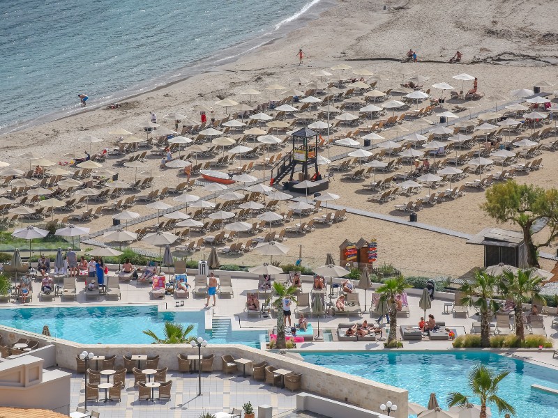 Uitzicht over het zwembad aan het terras en het strand tijdens een mooie dag in mei.