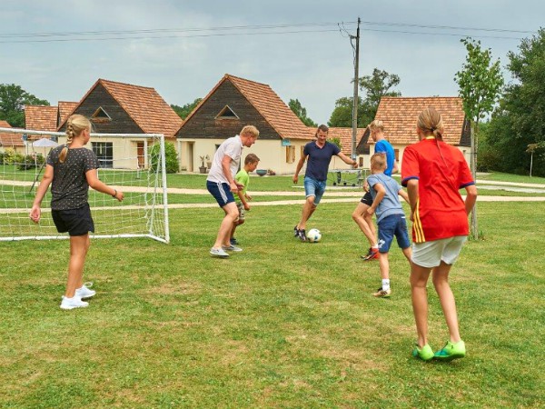 Voetballen op het gras rond de vakantiewoningen van Le Lac Bleu