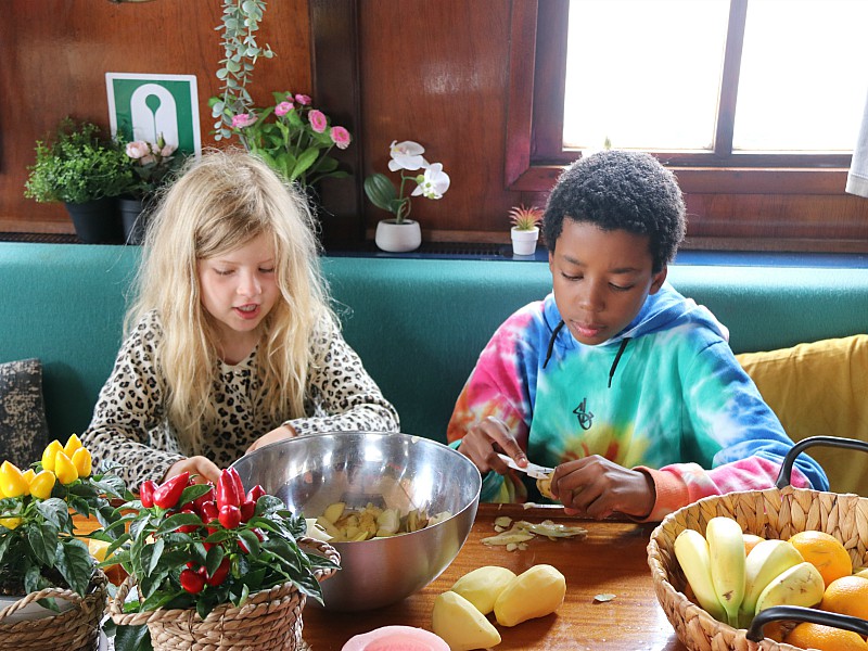 Ook de kids helpen ijverig mee met groente snijden.