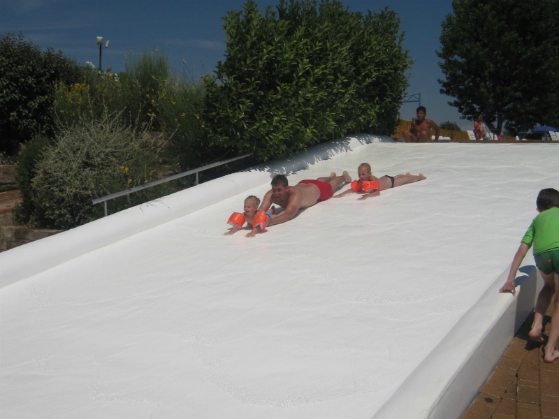 Vader gaat met zijn dochters van de glijbaan op Camping Albatros