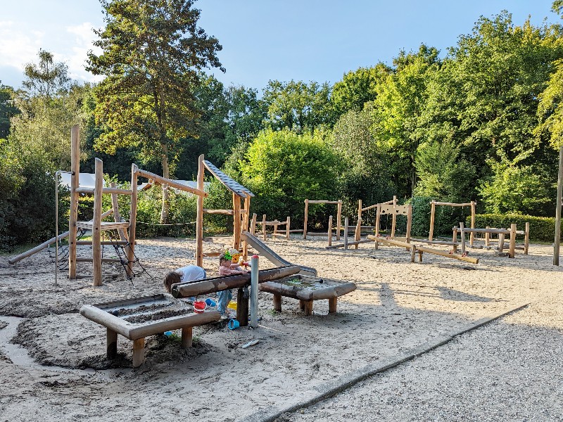 De kinderen spelen bij het waterspeelplekje