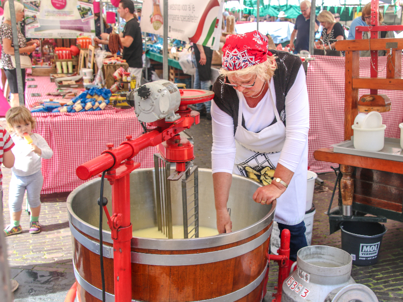 Een vrouw maakt kaas op de markt van Gouda