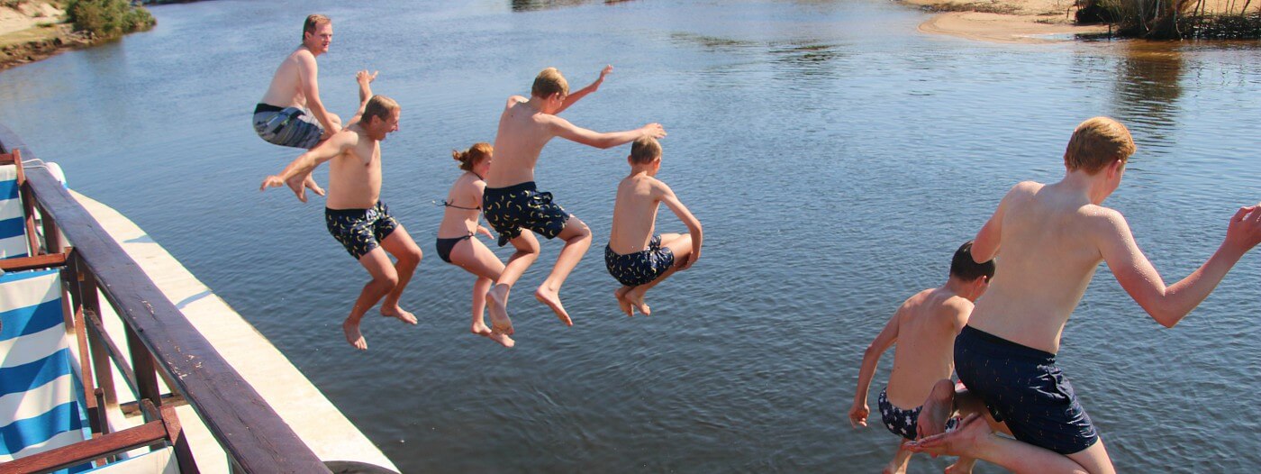 Alle kinderen springen van de boot in het Pangalanes kanaal in Madagascar