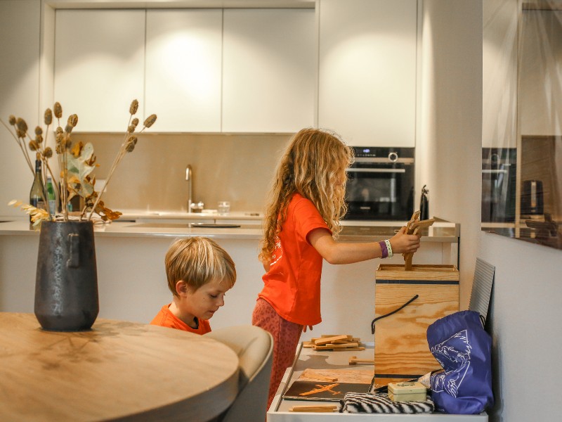 De kinderen van Elisabeth spelen aan tafel met het knutselpakket en het speelgoed van Hof van Saksen