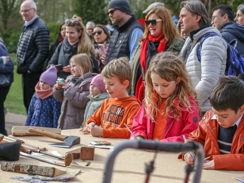 De kinderen van Elisabeth tekenen houtkrullen tijdens het oud hollands klompenmaken in de Keukenhof
