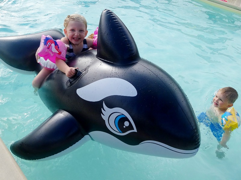 Meisje op de walvis in het zwembad