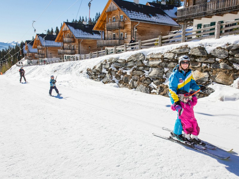 Skiën op de skipiste voor de vakantiehuisjes