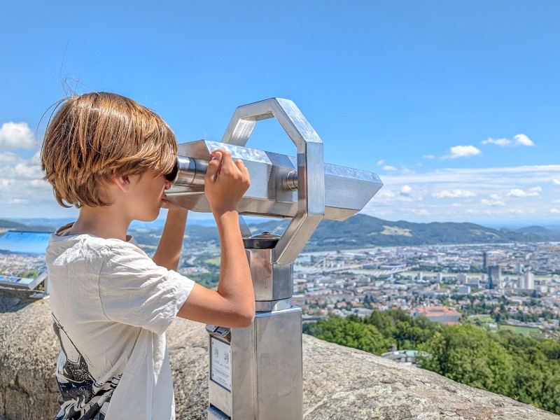 De zoon van Kim kijkt uit over Linz vanaf de Postberg in de stad, Opper-Oostenrijk