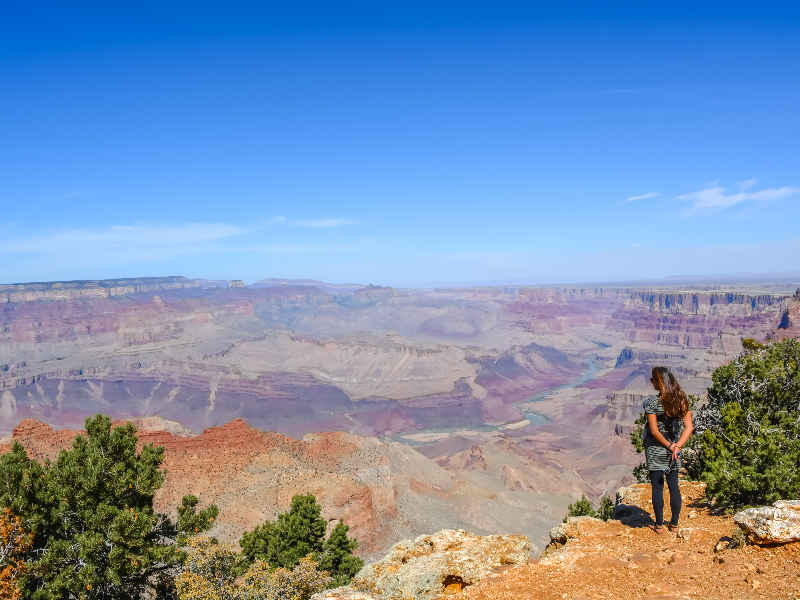 Lisette en haar baby kijken uit over het roestbruine landschap van de Grand Canyon
