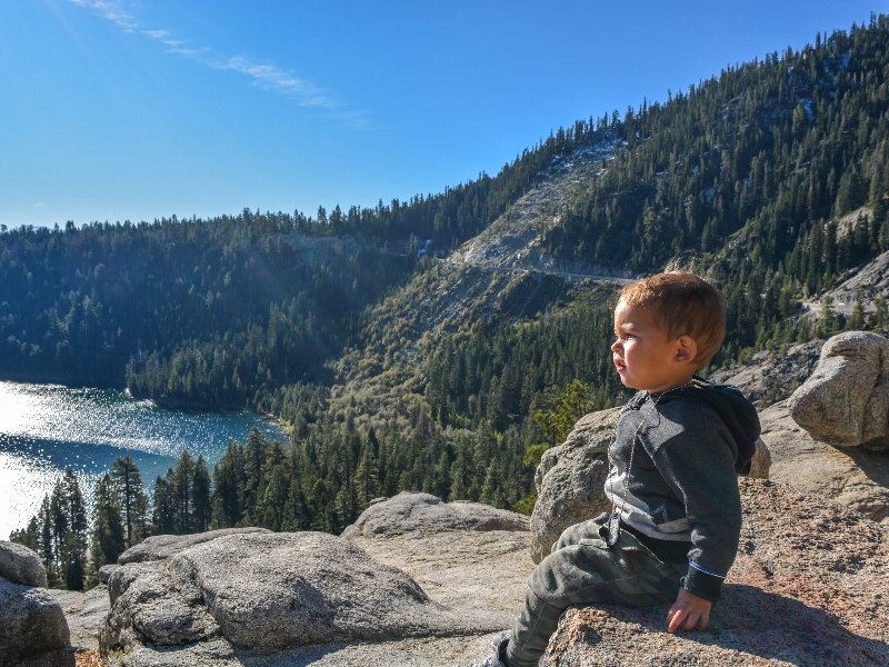 De peuter van Lisette kijkt uit over het water in yosemite National Park in West Amerika