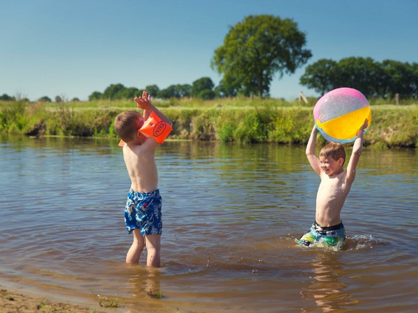 Kinderen spelen bij het strandje in het water