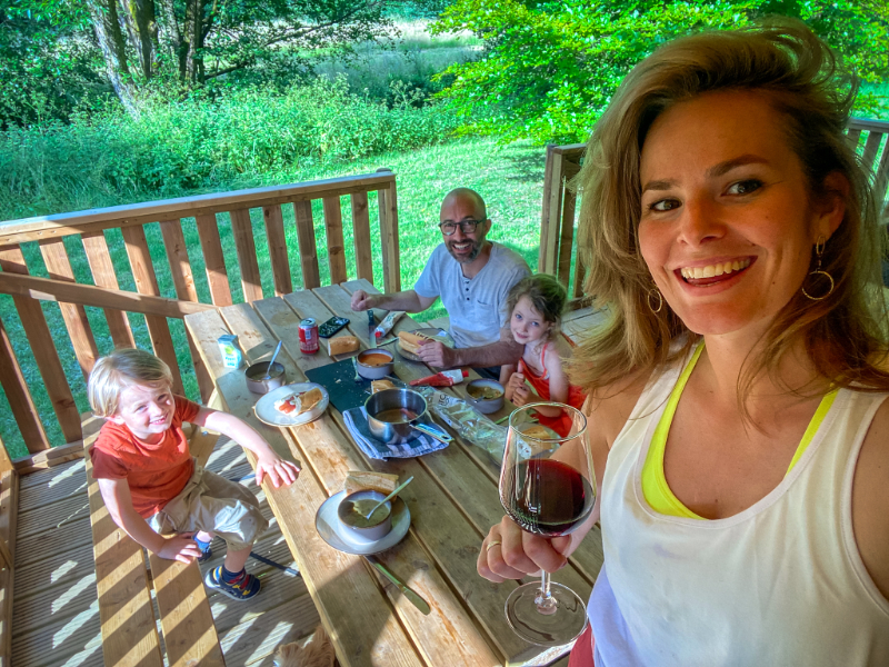 Elisbeth en haar gezin aan de picknicktafel op de veranda van hun tent op Landal Neufchateau
