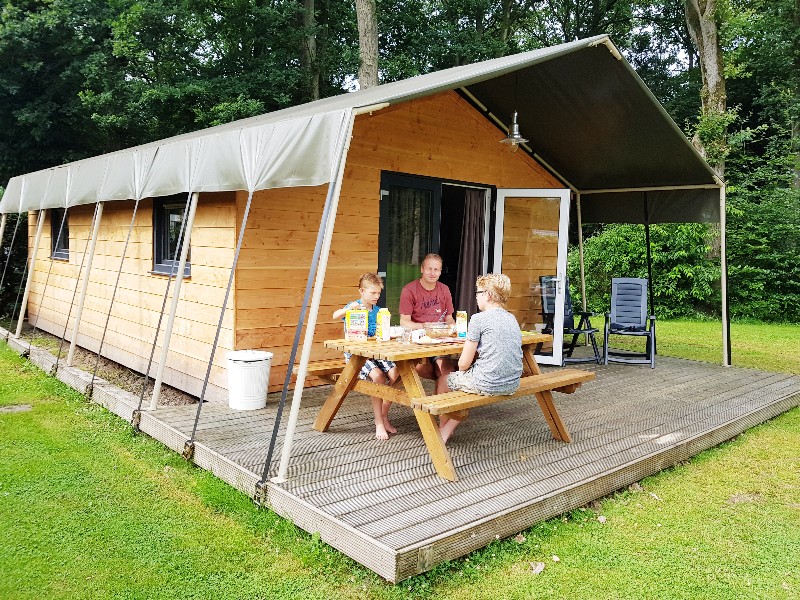 We ontbijten op de veranda van onze safarilodge bij Camping de Noetselerberg