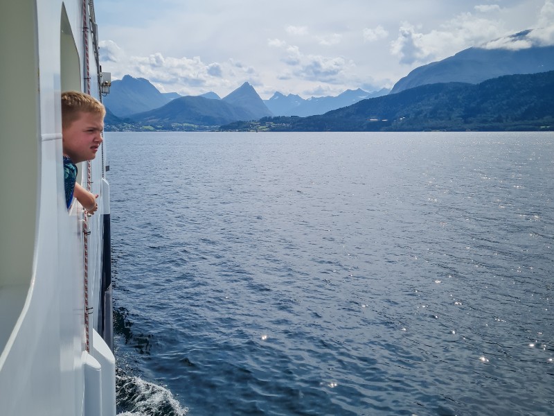 In het westen van Noorwegen stap je tijdens een rondreis regelmatig op de boot, zoals de zoon van Alma hier
