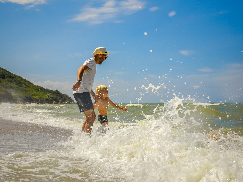 Vader en zoon in de zee aan de Noord Franse kust vann Normandië
