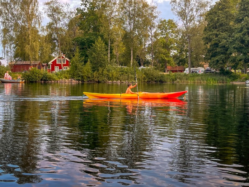 De kinderen kanoën op het meer bij Ödevata