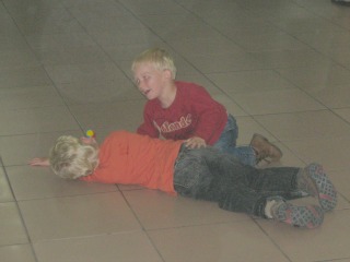 De jongens spelen op de grond voor de douane De jongens spelen op de grond voor de douane