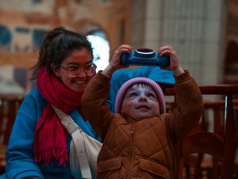 De zoon van Mathias maakt foto's van het plafond in de kathedraal van Boulogne-sur-Mer