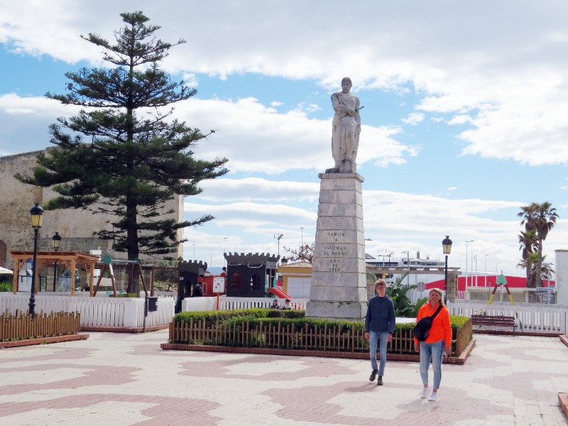 We wandelen op het centrale plein met standbeeld in Tarifa