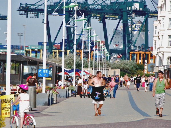 De promenade in Zeebrugge, met de kranen in de haven op de achtergrond