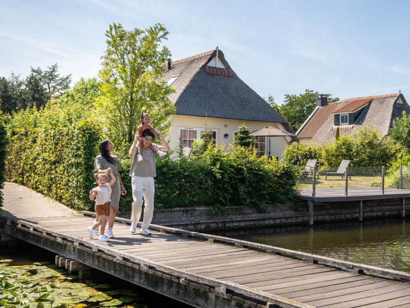 Gezin wandelt tussen de bungalows van Landal Domein De Schatberg