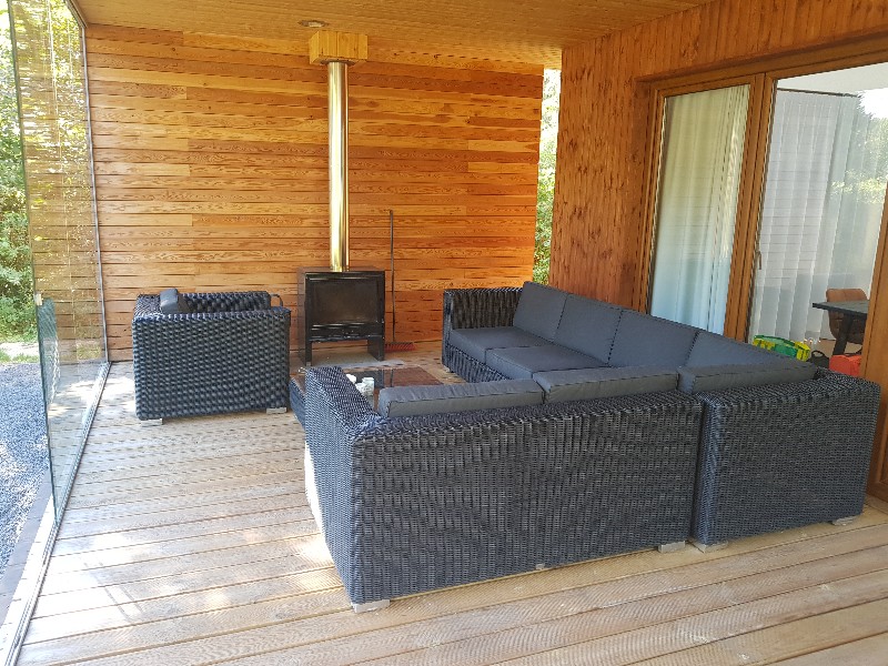 De ruime veranda met houtkachel