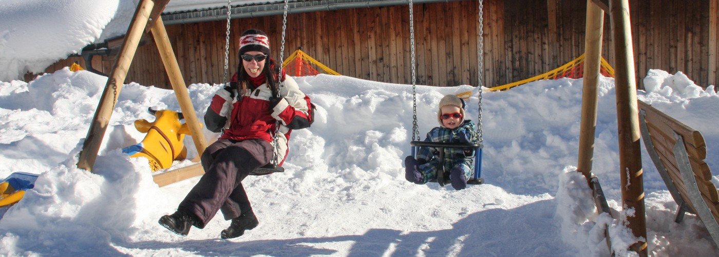 Samen op de schommel tijdens een gezinsvakantie op wintersport bestemming Serfaus-Fiss-Ladis