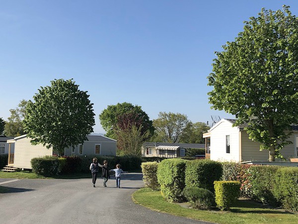 Kinderen wandelen langs de stacaravans