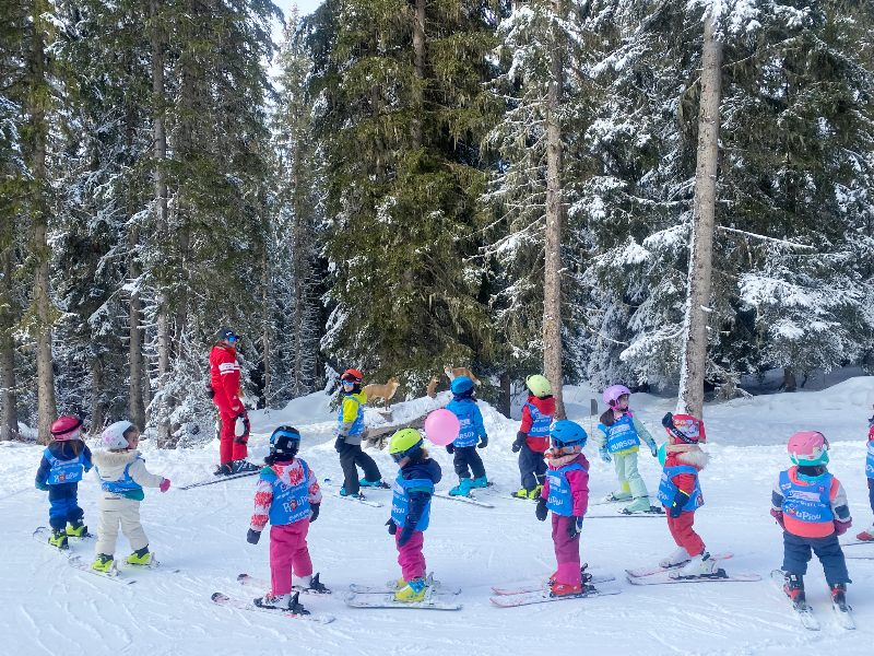 Een klasje met kinderen skiet de route du Animaux in Meribel door het bos